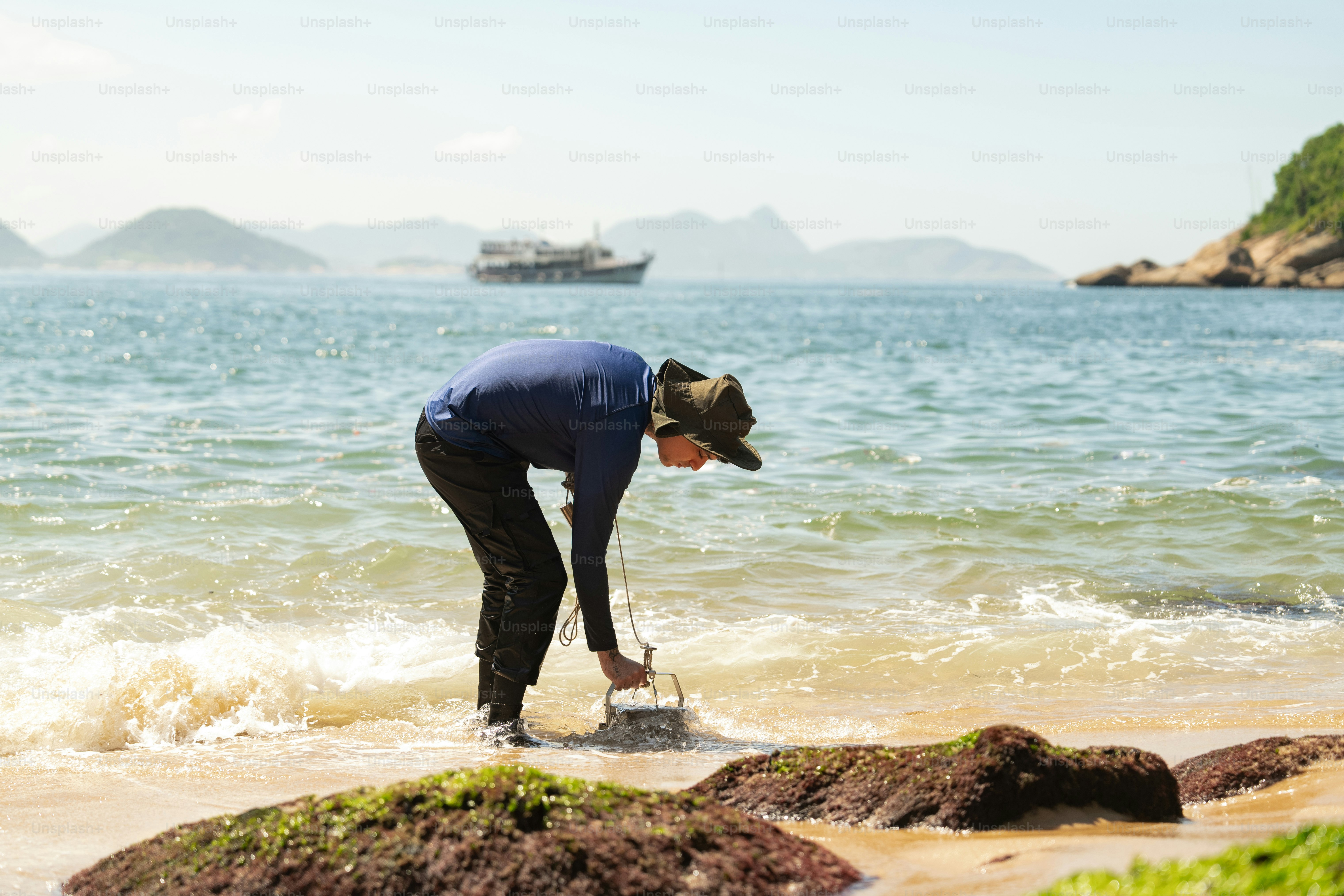 A man standing on top of a sandy beach next to the ocean photo – Beach ...