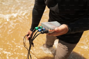 a person holding a device in the water