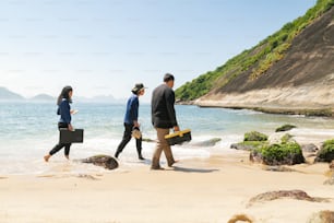 un gruppo di persone che camminano lungo una spiaggia vicino all'oceano