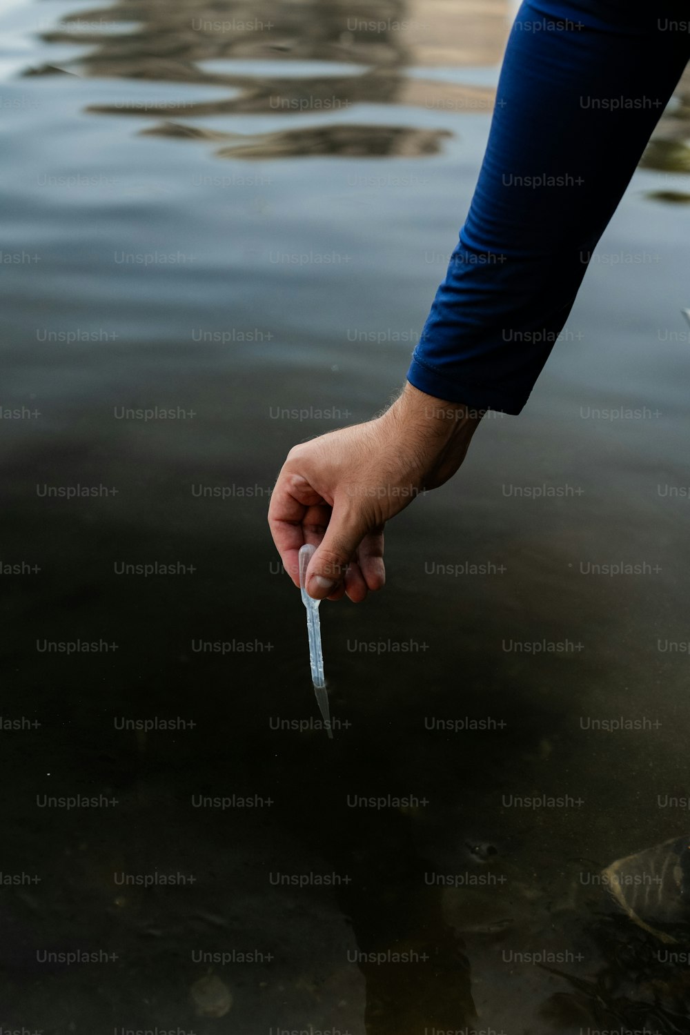 una persona sosteniendo un cuchillo en el agua