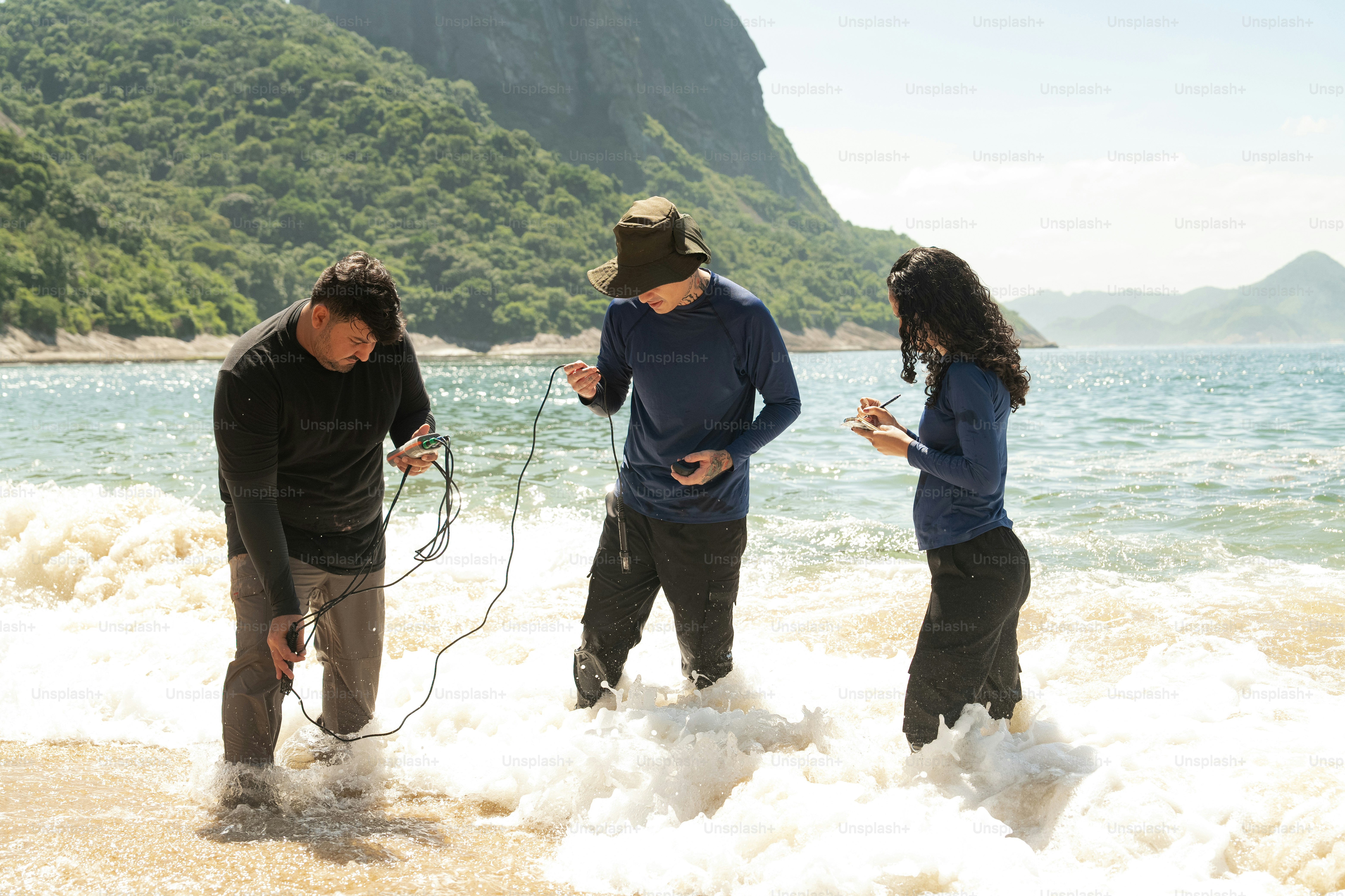 un groupe de personnes debout au sommet d’une plage de sable