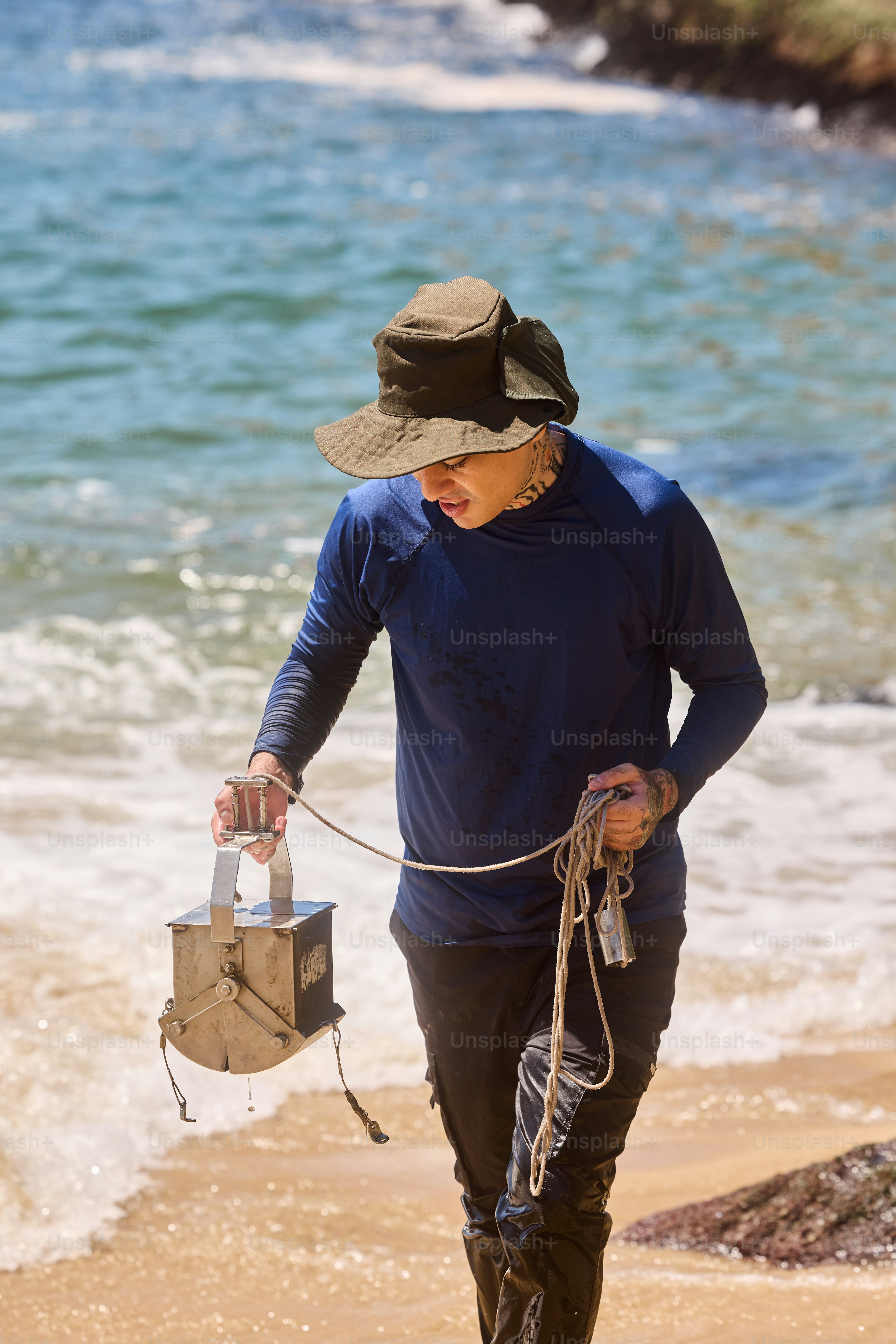 una donna che cammina sulla spiaggia con un cappello