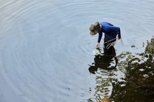 a man in a hat is wading in the water