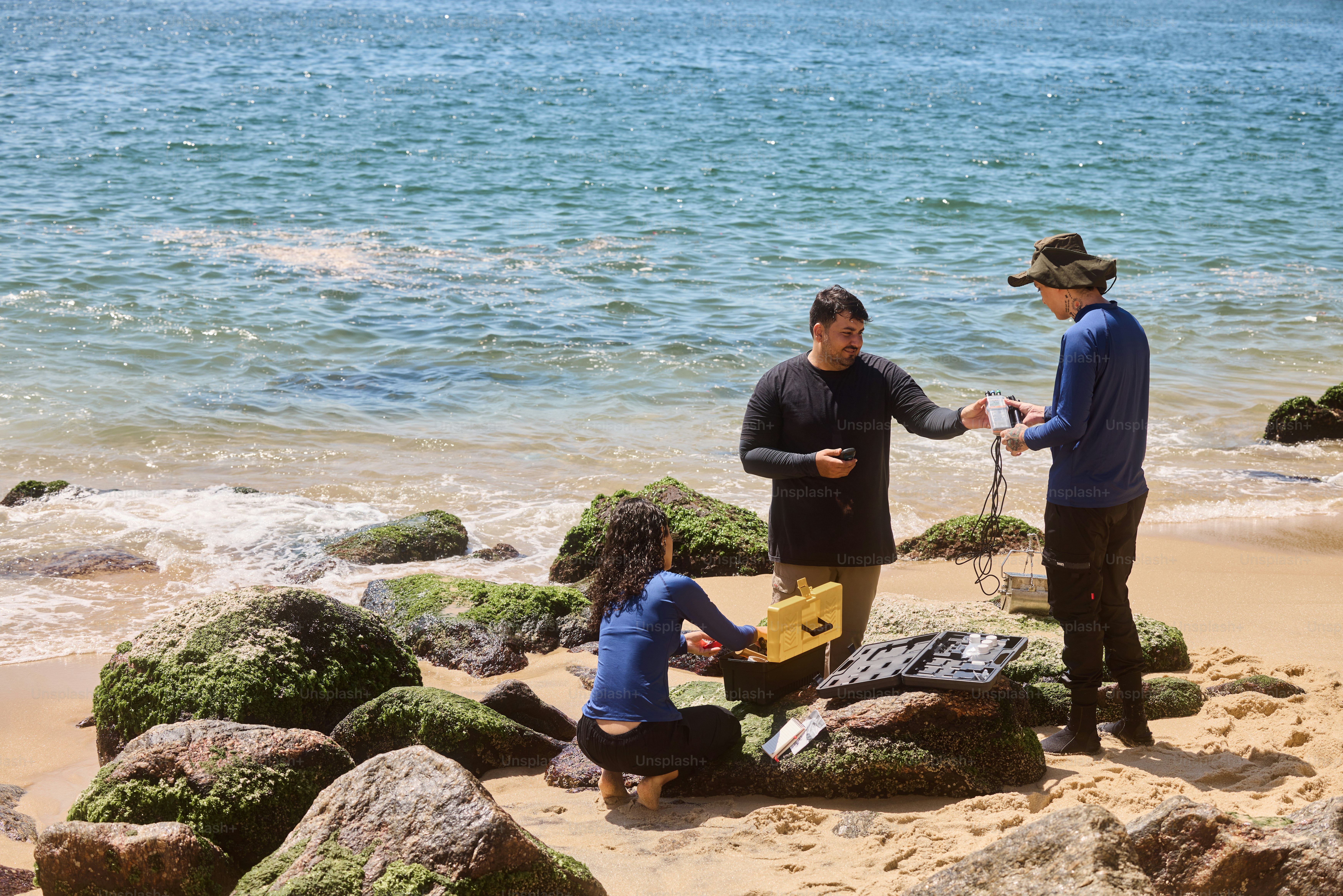 un groupe de personnes debout au sommet d’une plage de sable