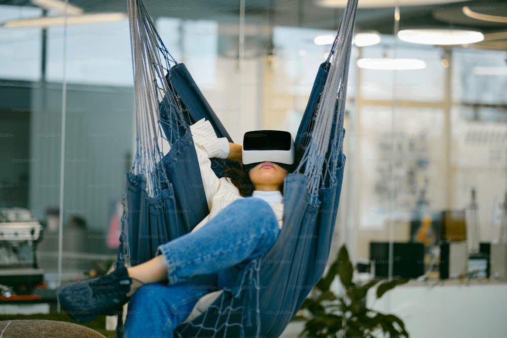 a woman laying in a hammock in an office