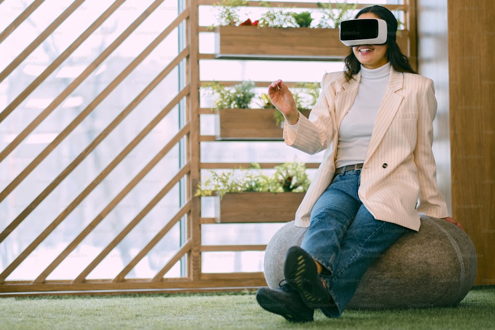 a woman sitting on top of a ball wearing a virtual headset