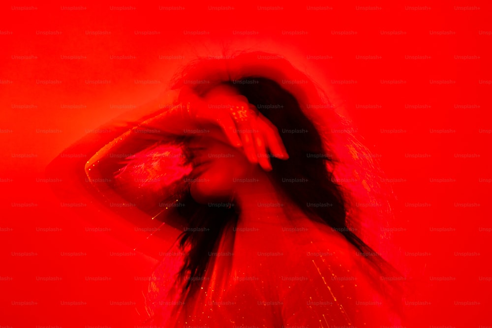 uma mulher com cabelo comprido em pé em uma sala vermelha