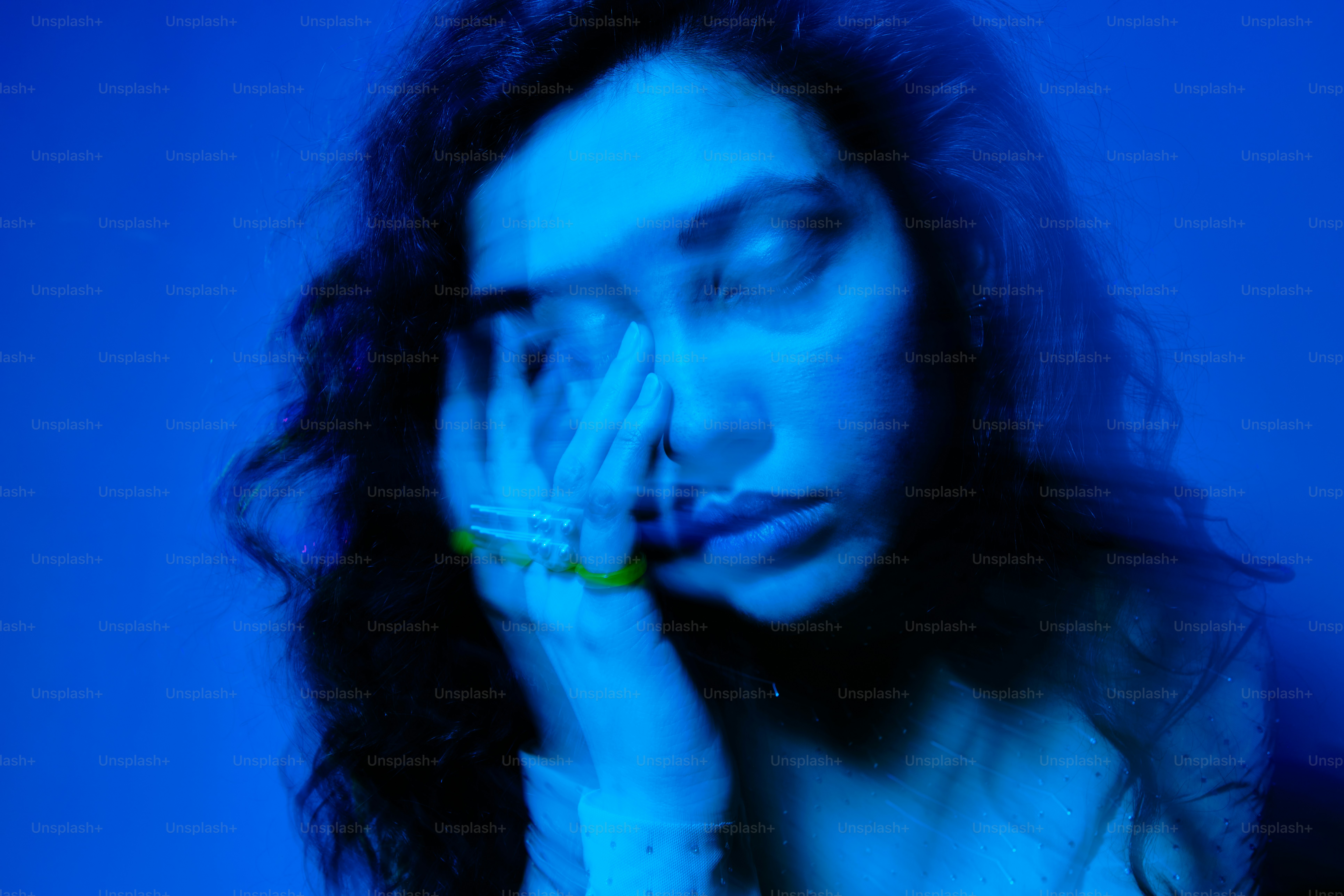 a woman holding her hand to her face