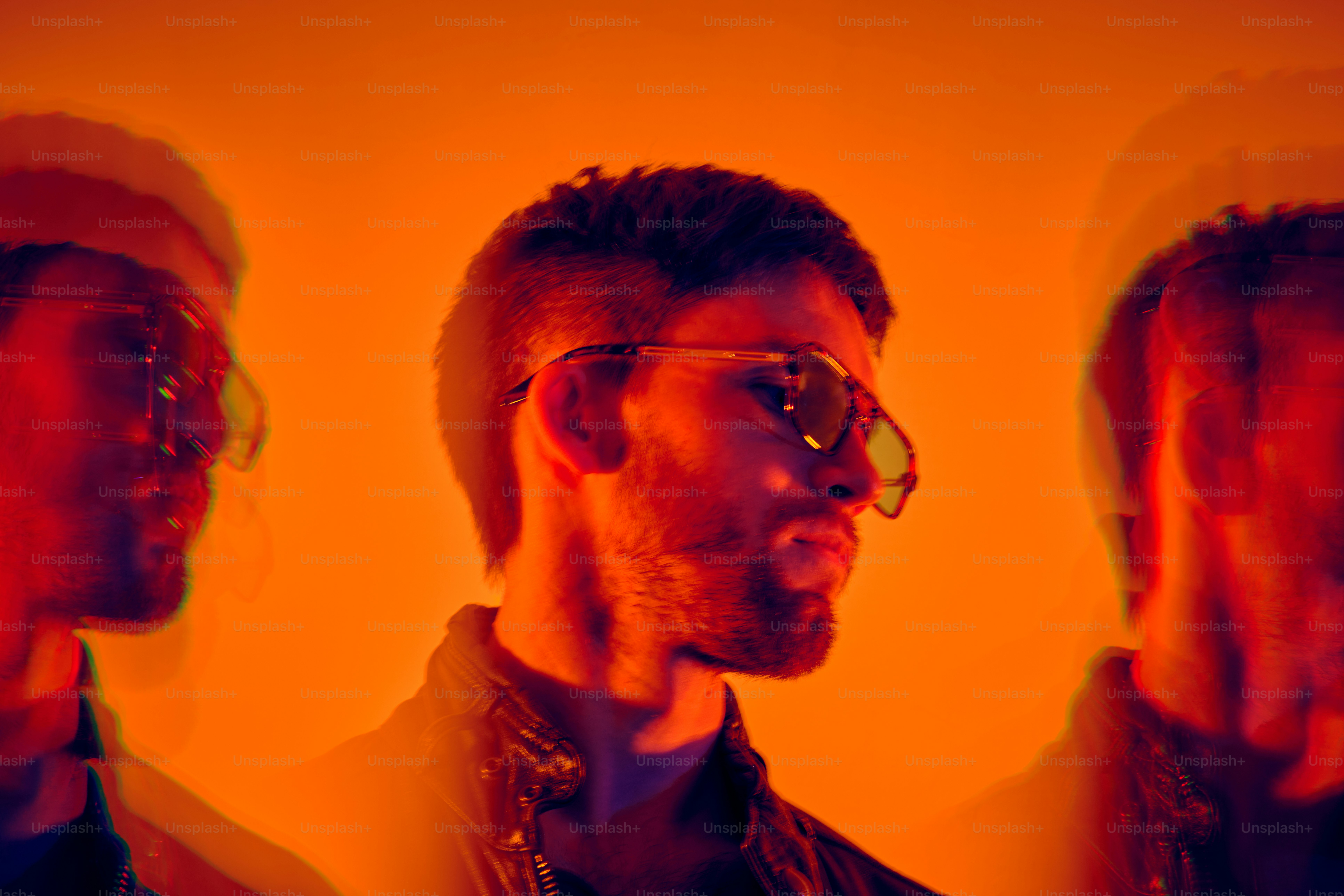 Ein Mann mit Brille steht vor einer gelben Wand