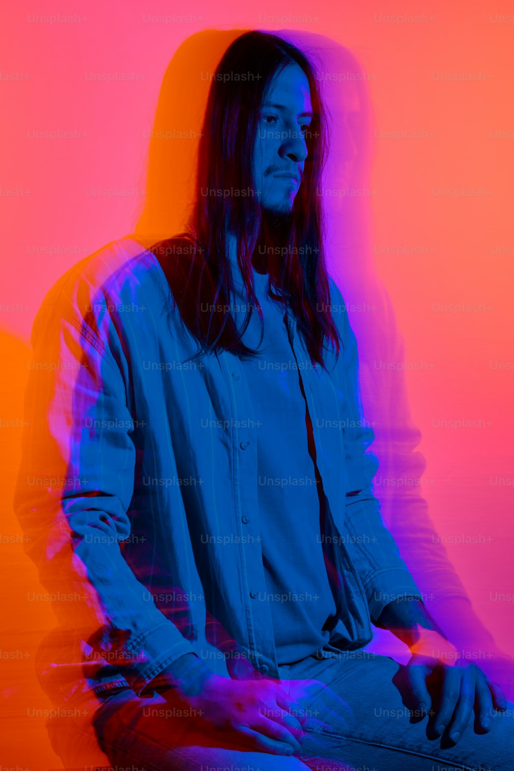 a man with long hair sitting in a chair