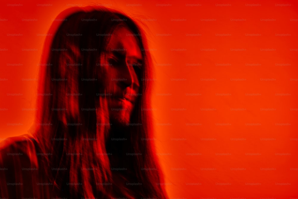 a woman with long hair standing in front of a red background