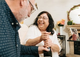 a woman holding a bottle of wine next to a man