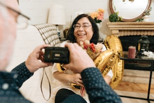 a woman taking a picture of a man in a living room