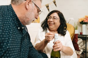 a man holding a bottle of wine next to a woman