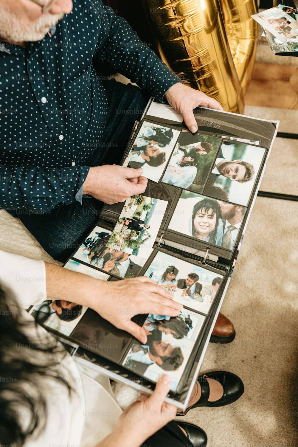 a man and a woman looking at photos on a table