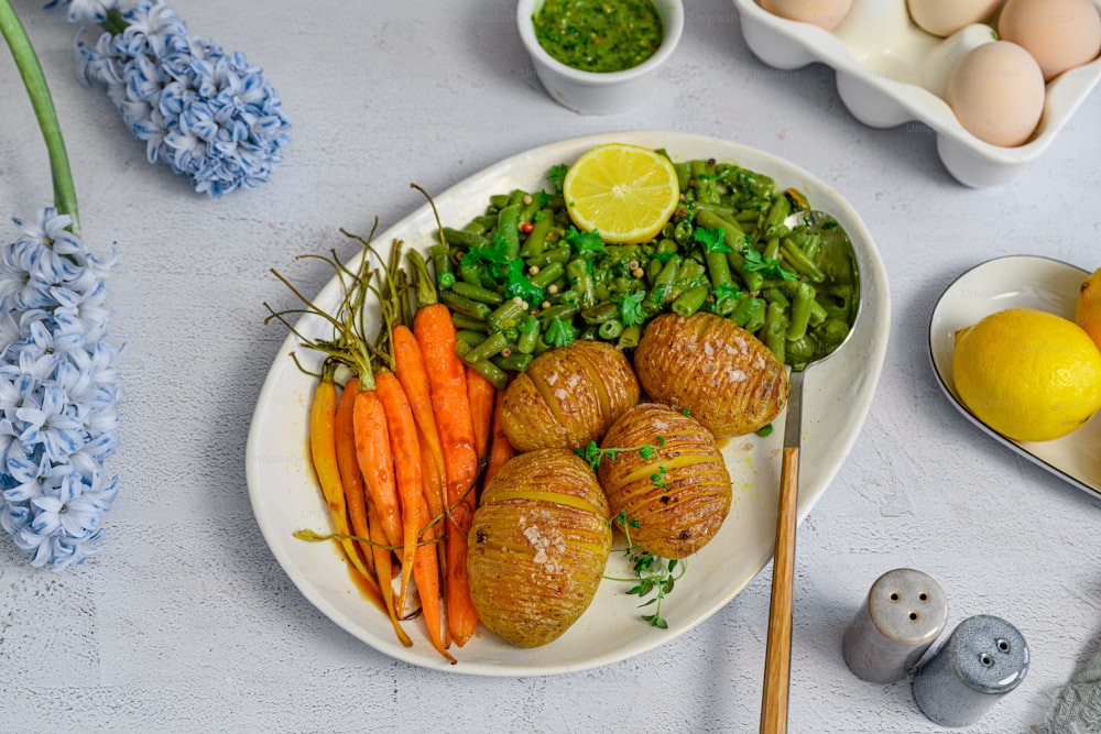 a plate of food with carrots, peas, peas and lemons