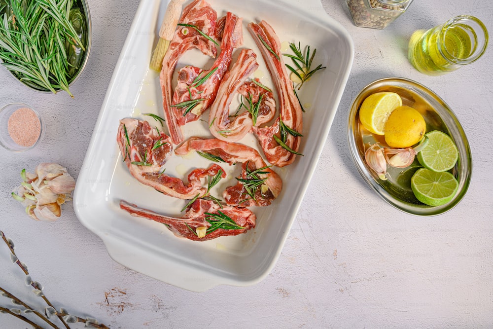 a tray of raw shrimp with herbs and lemons