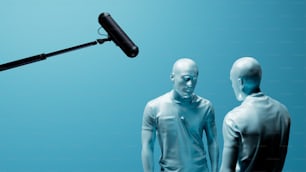 un micro et deux mannequins debout devant un fond bleu