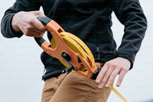 a man holding a measuring tape and a pair of scissors