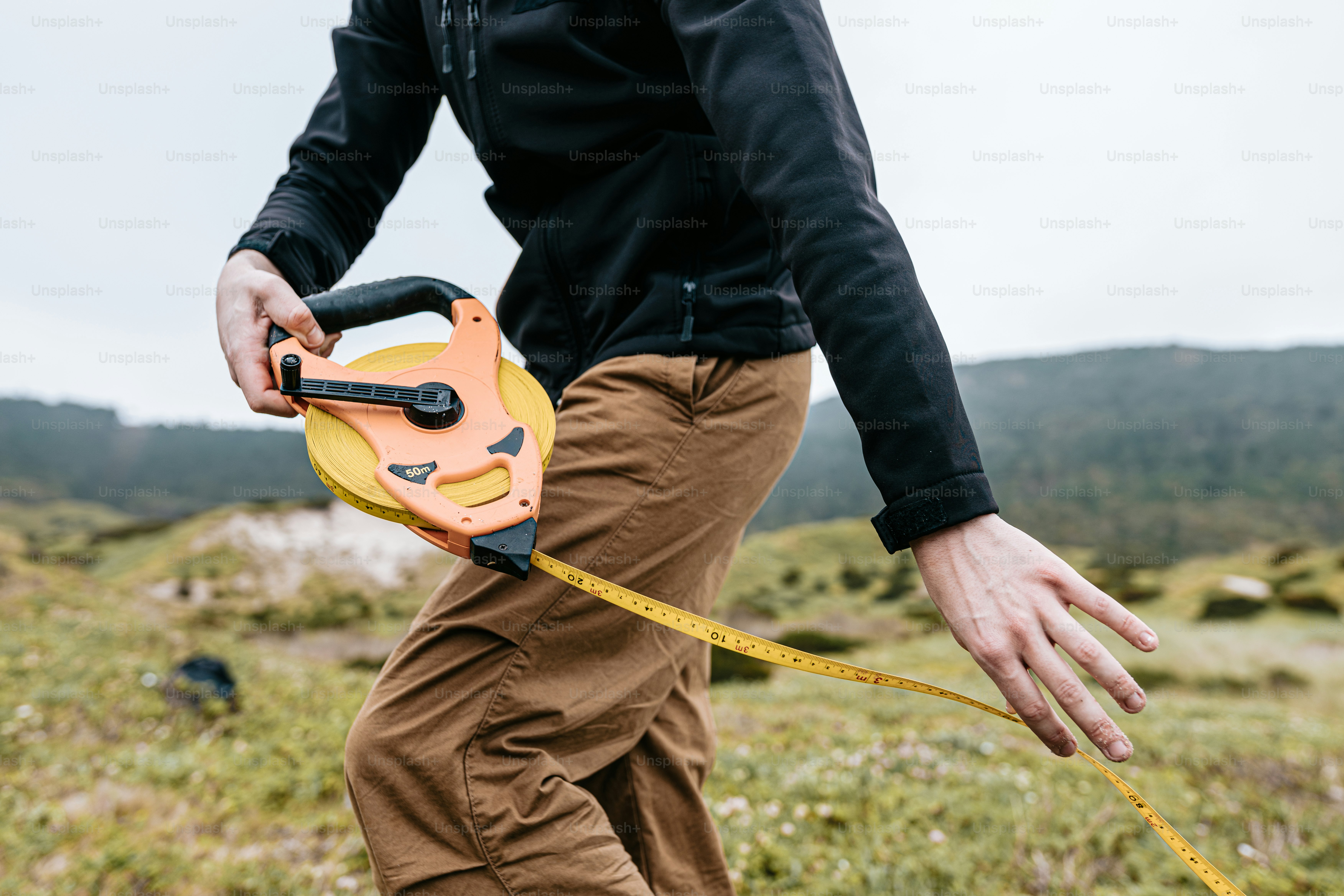 a man holding a yellow and black device in his hand