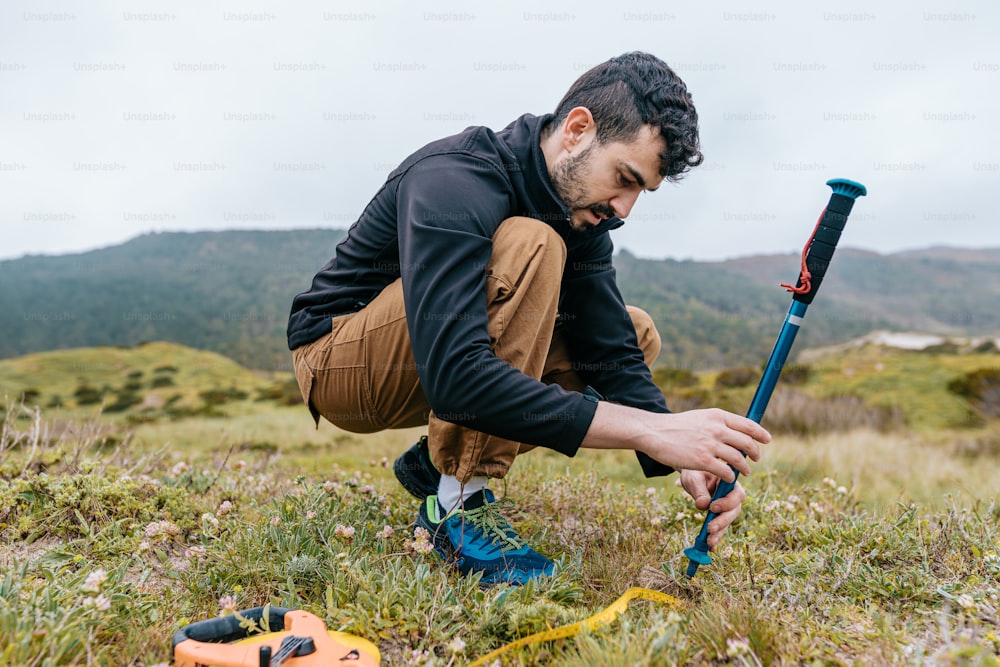 a man kneeling down in the grass with a baseball bat