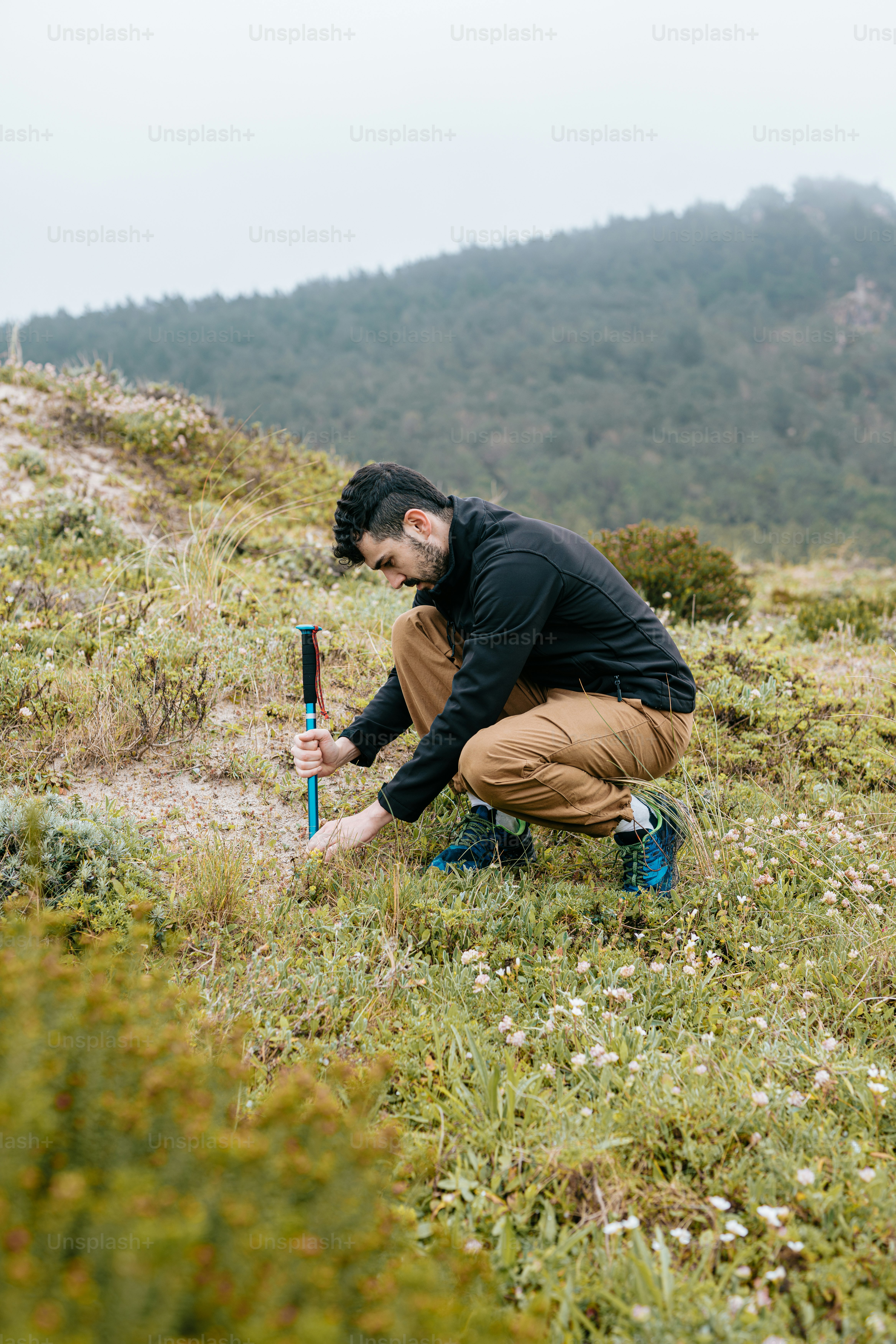 a man kneeling down in a field holding a baseball bat