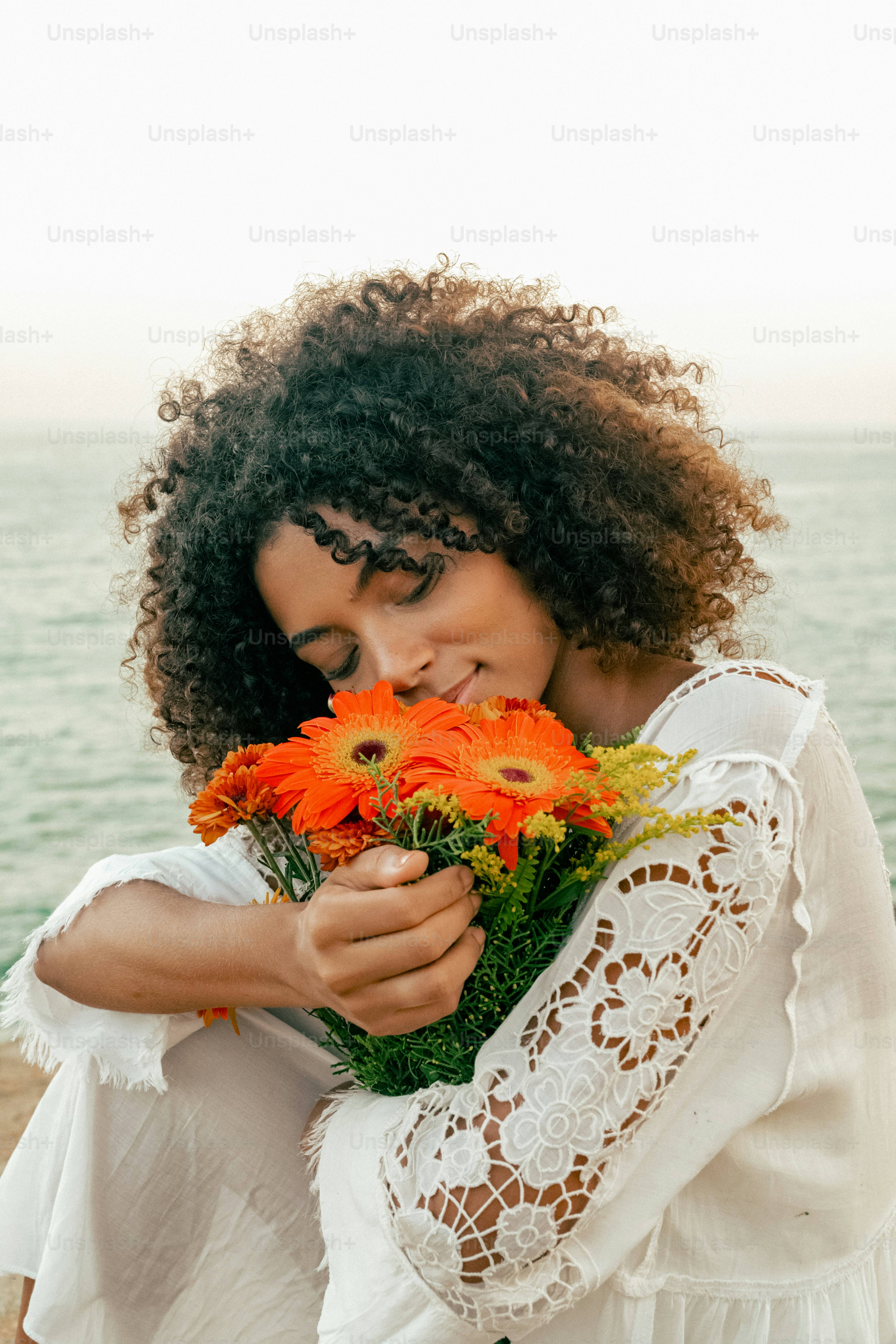 a woman in a white dress holding a bouquet of flowers
