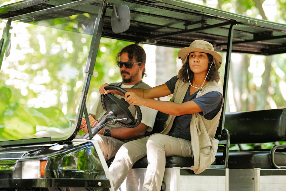 a man and a woman riding in a golf cart
