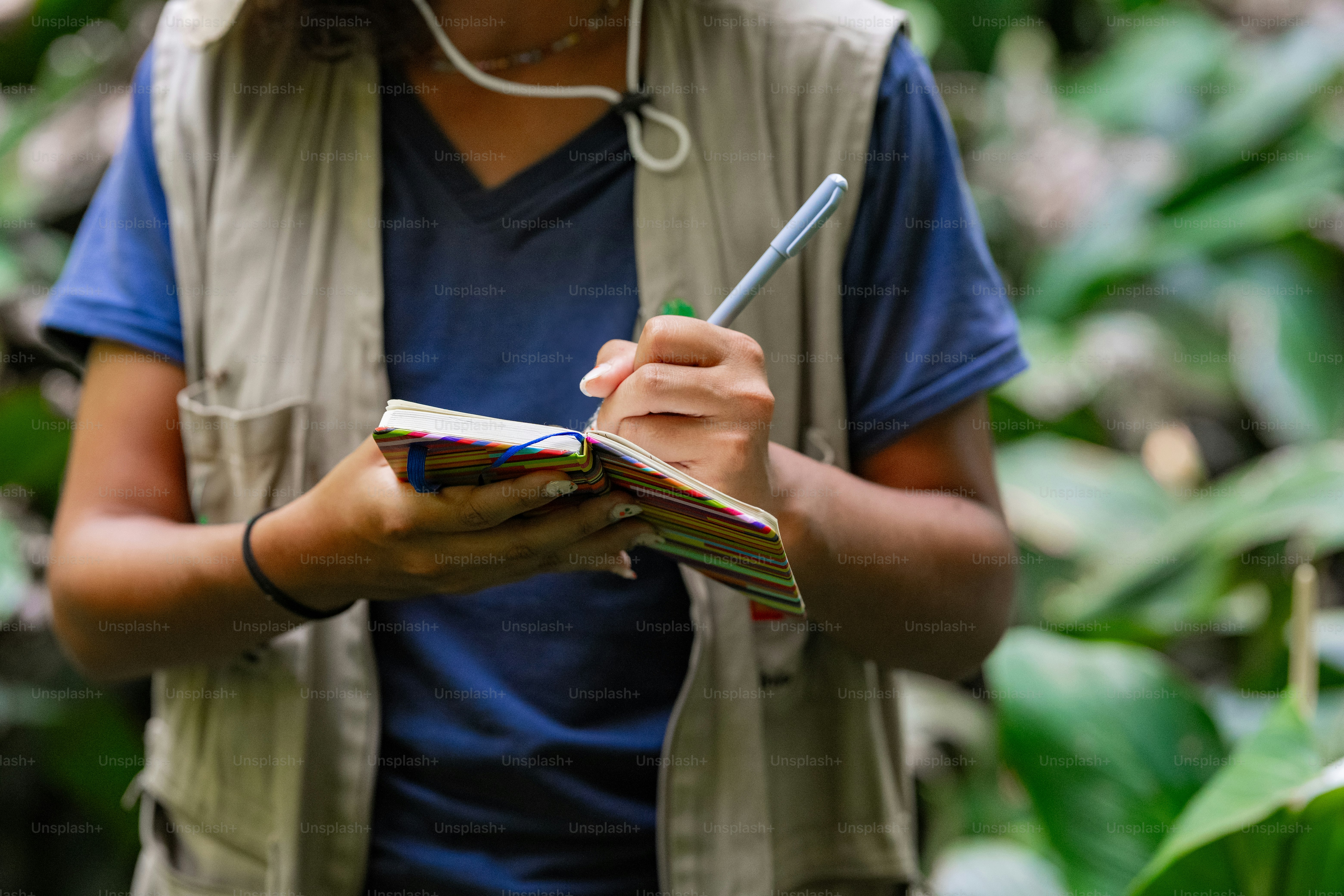 a woman holding a notebook and a pen in her hand