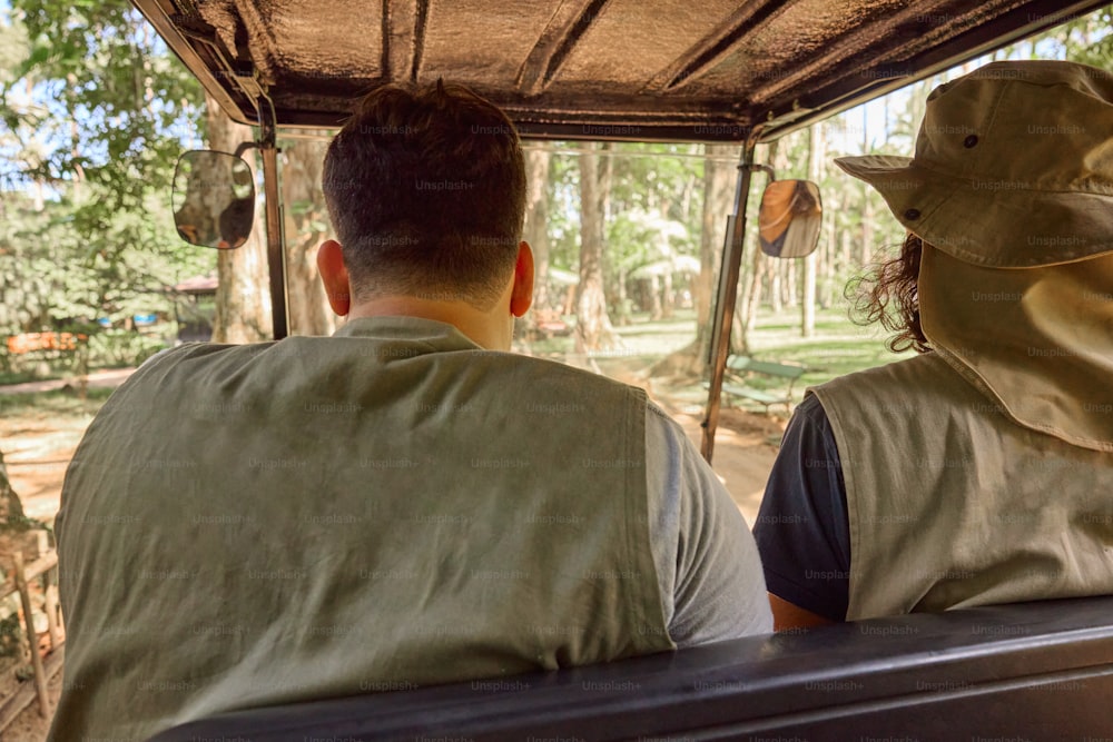 a man and a woman sitting in a covered vehicle