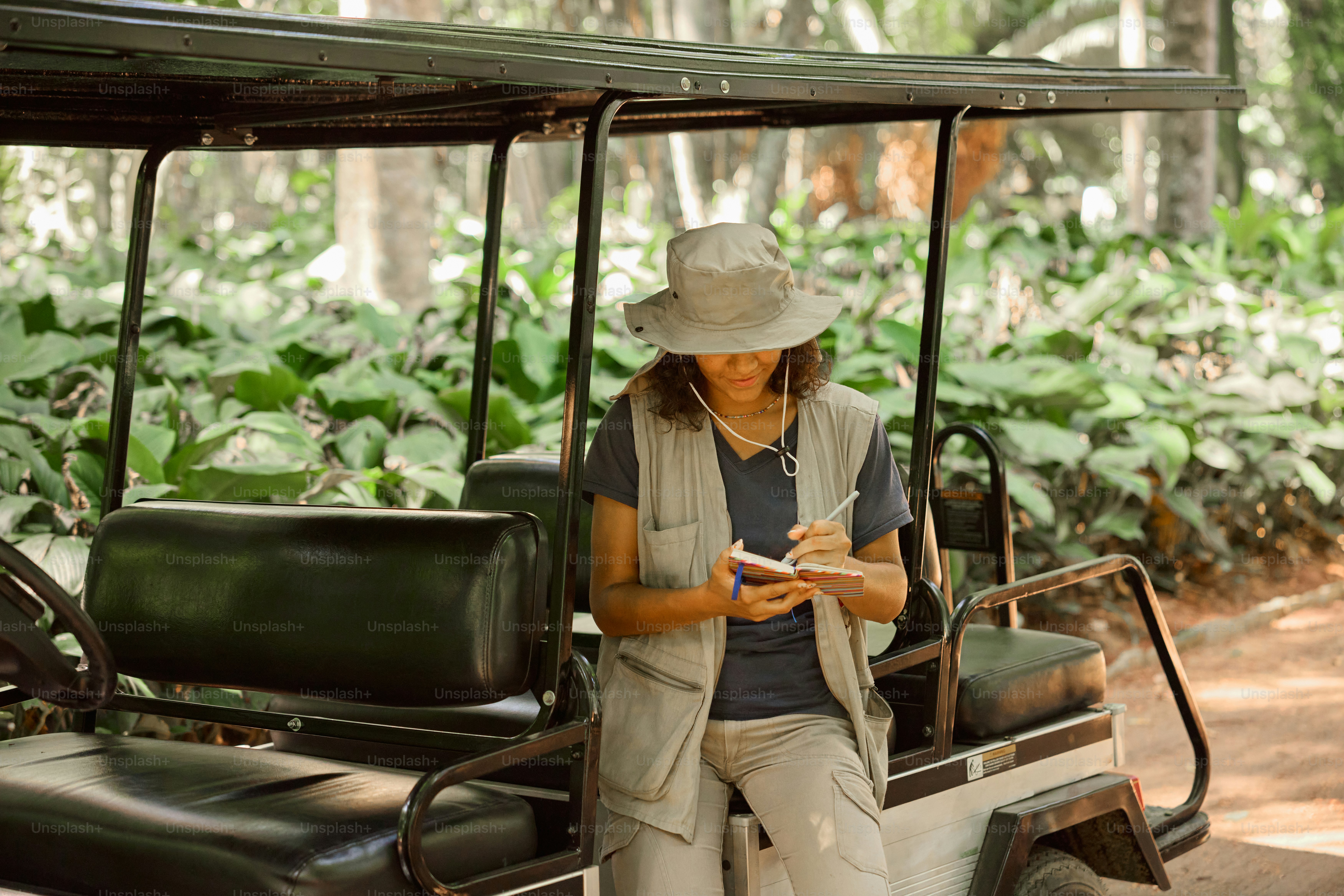 a woman in a hat is sitting on a golf cart
