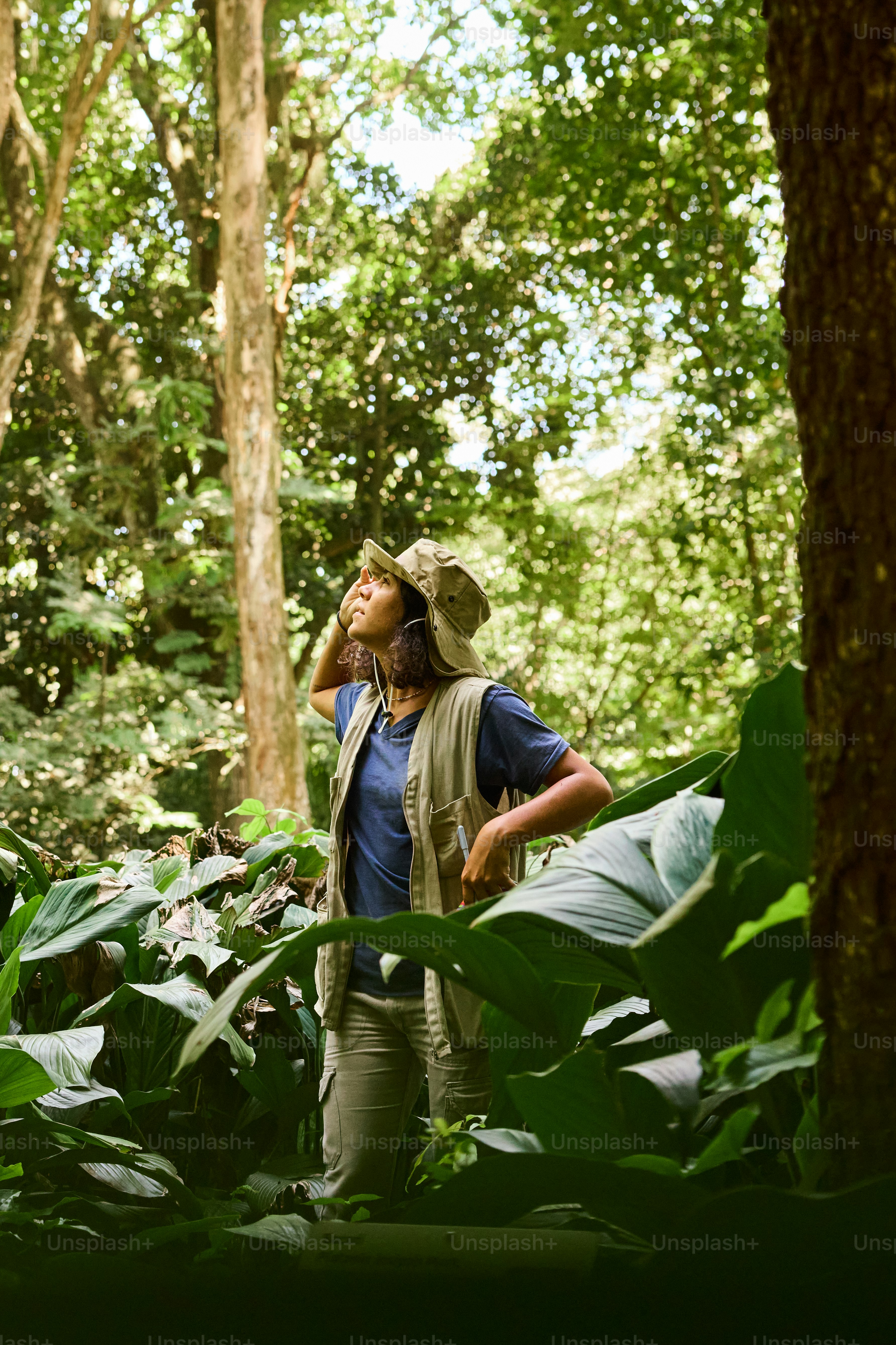 a man standing in the middle of a forest talking on a cell phone