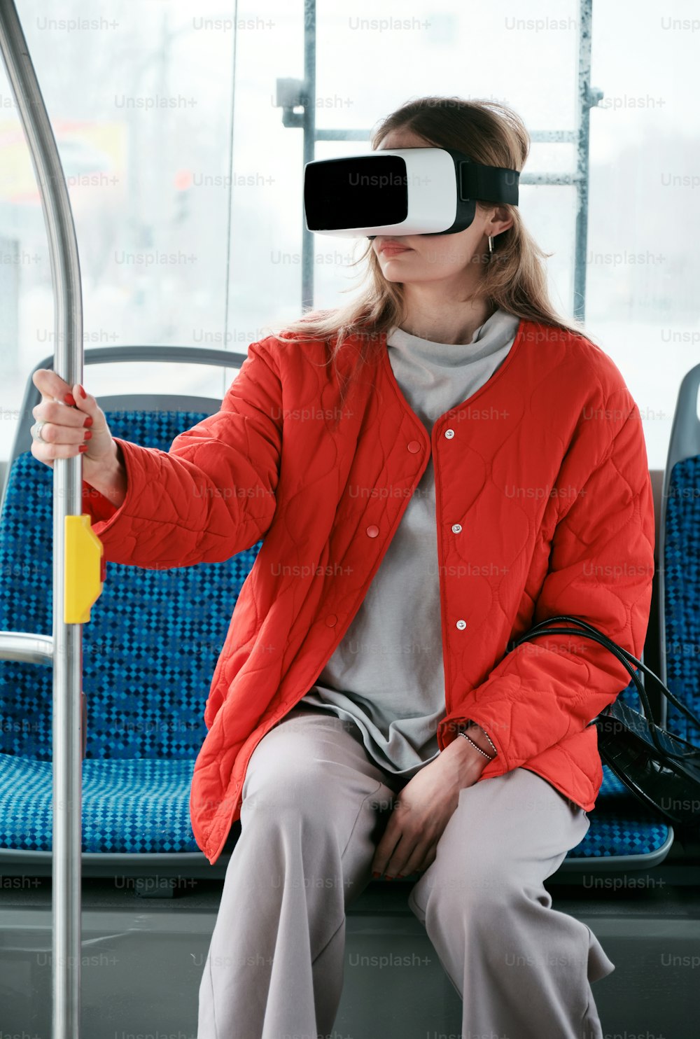Una donna seduta su un autobus che indossa un paio di occhiali virtuali