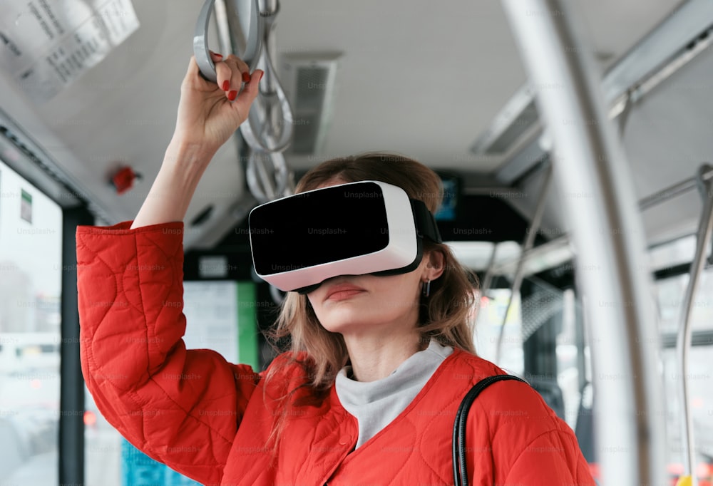 Uma mulher com uma jaqueta vermelha está usando um dispositivo de realidade virtual
