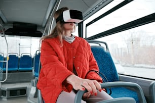 a woman sitting on a bus wearing a virtual headset