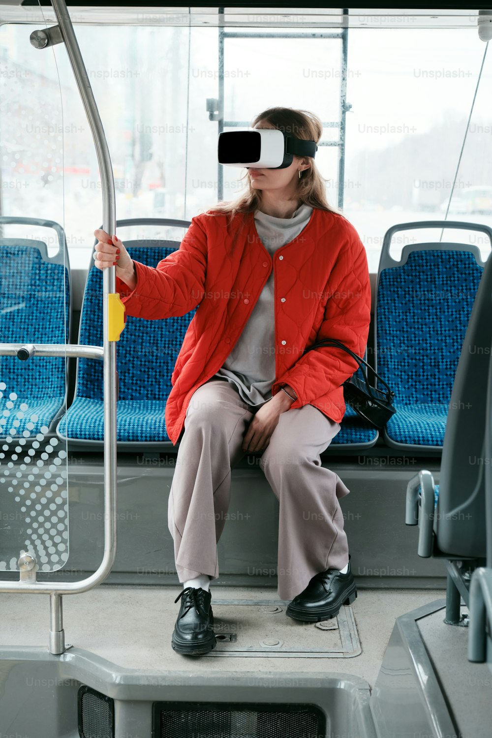 a woman sitting on a bus wearing a blindfold