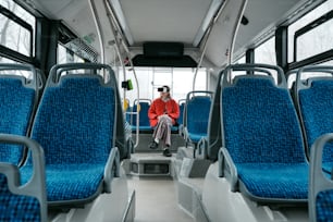 una persona seduta su un autobus con sedili blu
