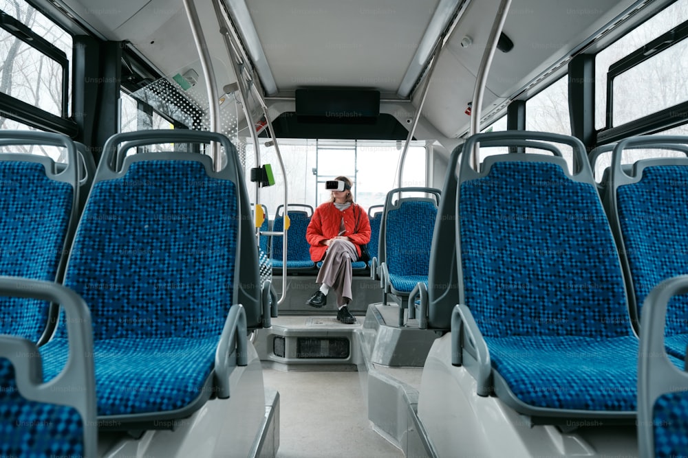 une personne assise dans un autobus avec des sièges bleus