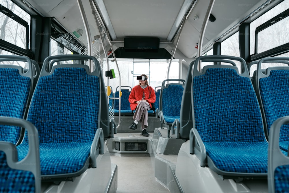 a person sitting on a bus with blue seats