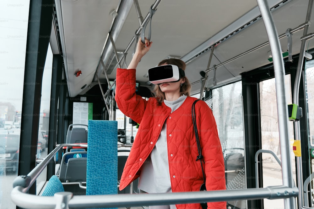 a woman in a red jacket is using a virtual device