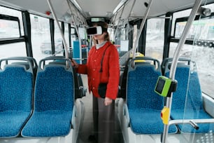 a woman standing on a bus wearing a virtual headset