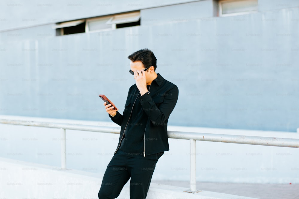 ein Mann in einem schwarzen Anzug, der mit einem Handy telefoniert