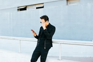 a man in a black suit talking on a cell phone