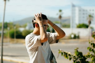 a man standing on the side of a road holding his hands up to his face