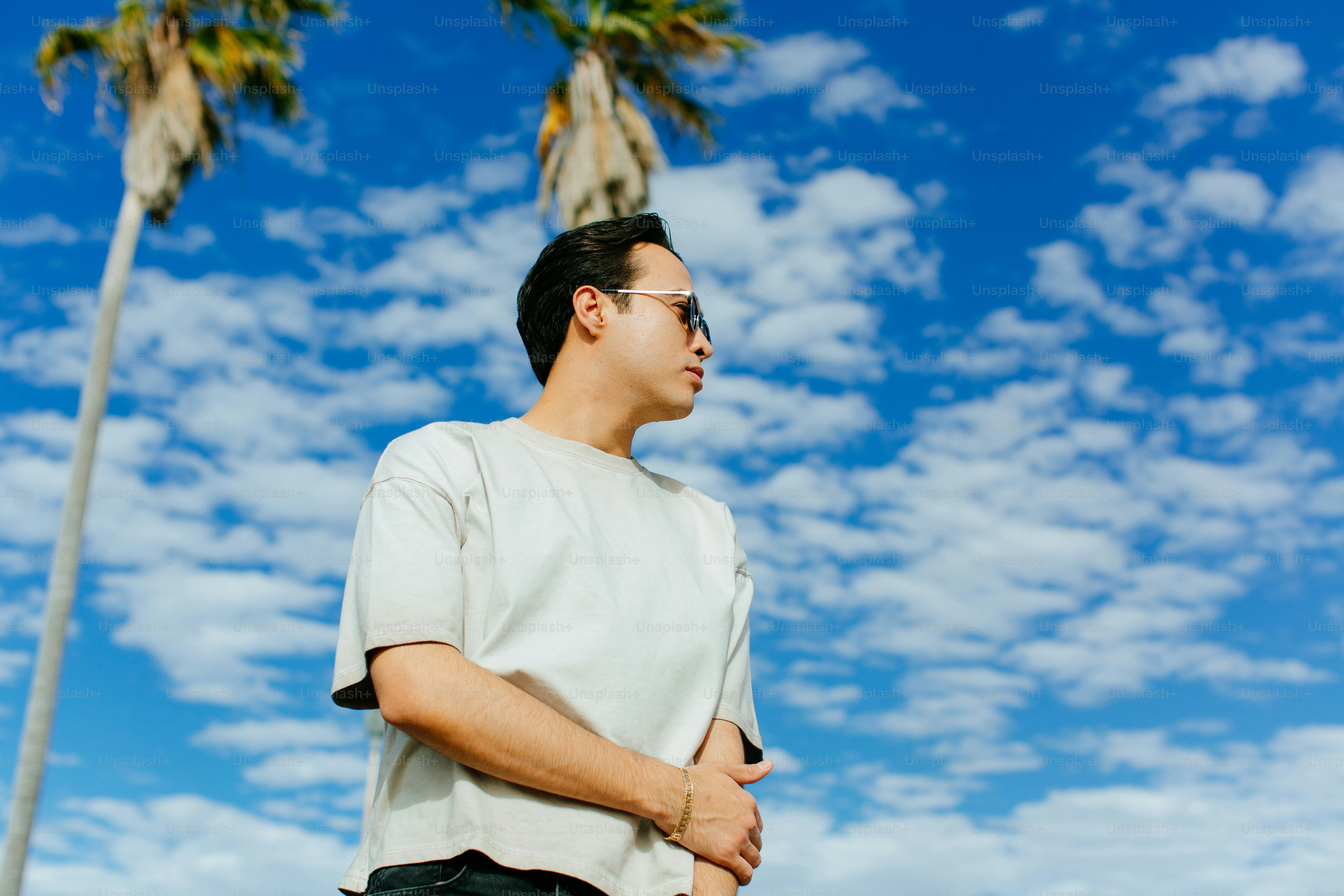a man standing in front of a palm tree