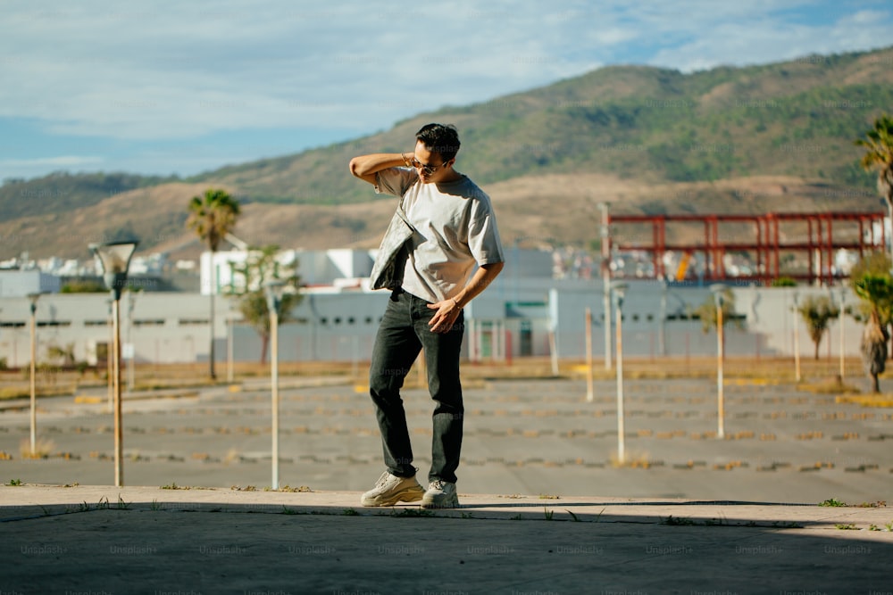 a man is standing on a skateboard in a parking lot