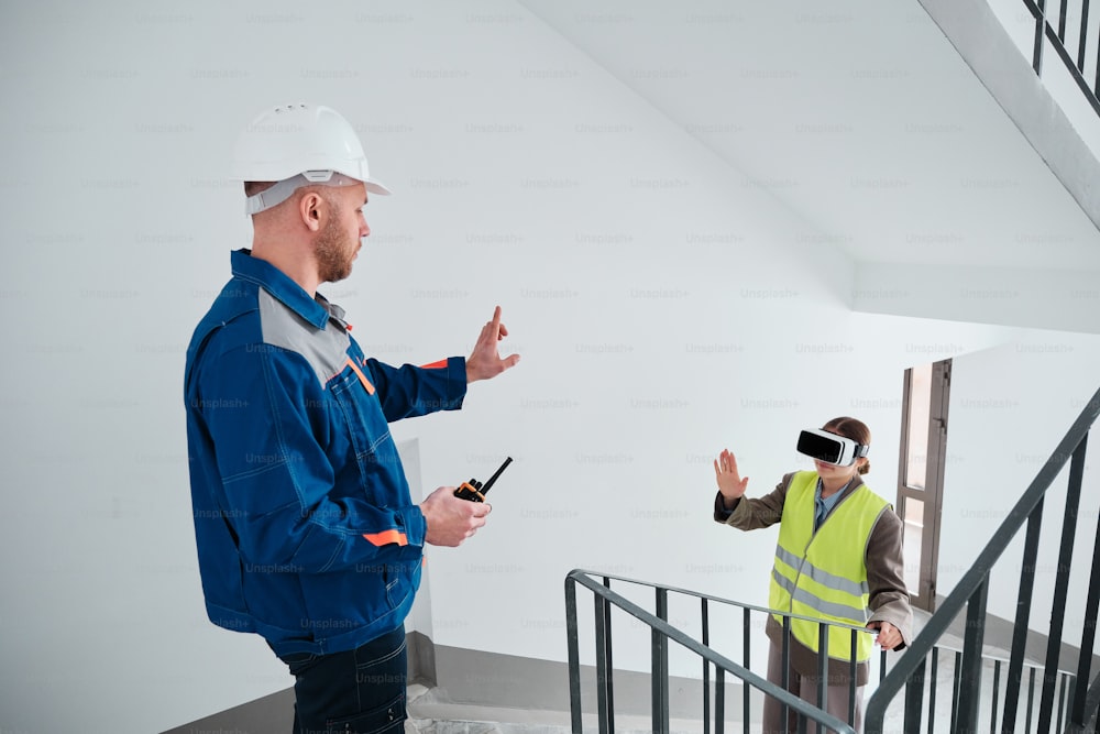 a man in a hard hat standing next to a man in a safety vest