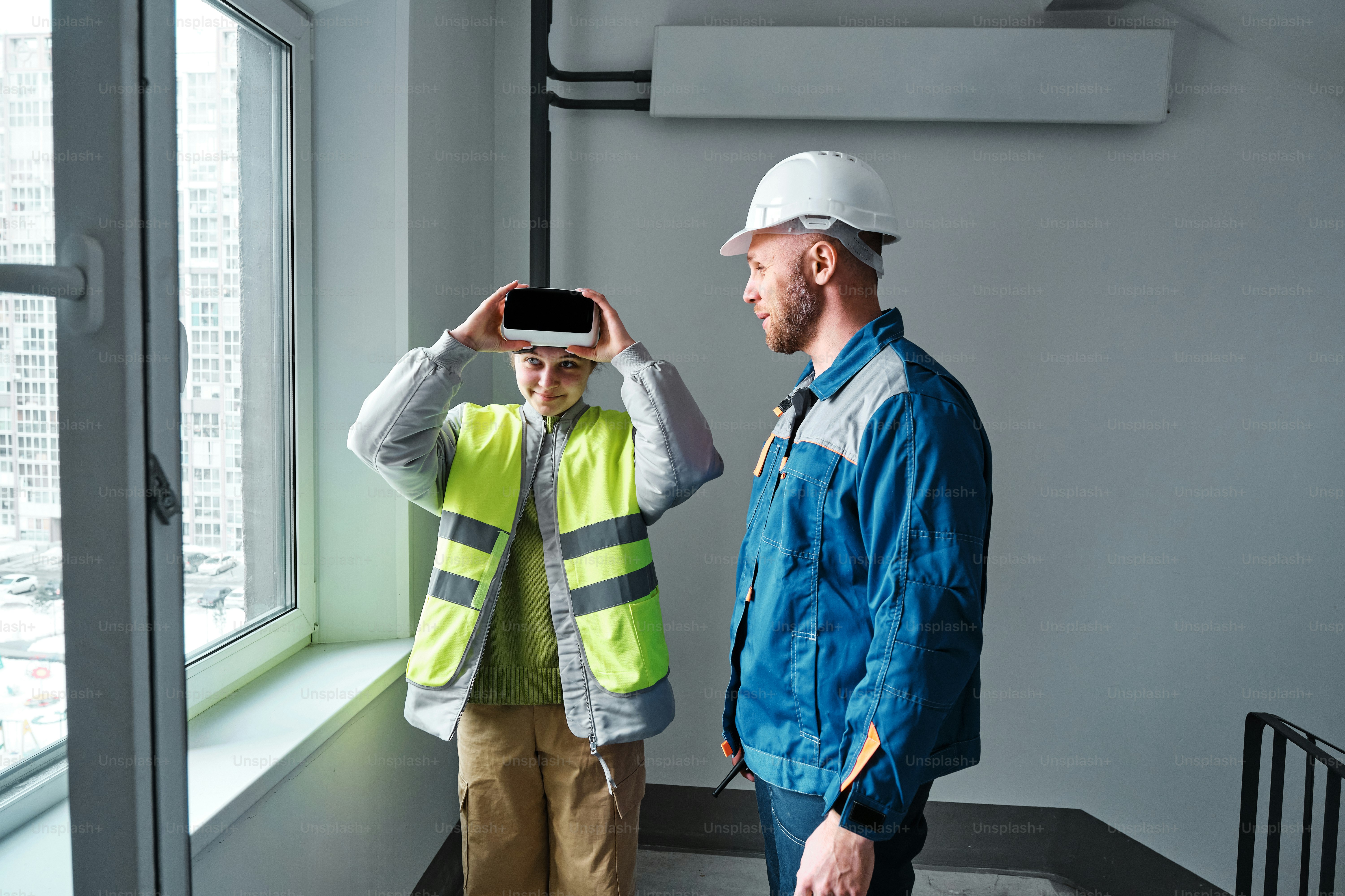 a man standing next to a man wearing a hard hat