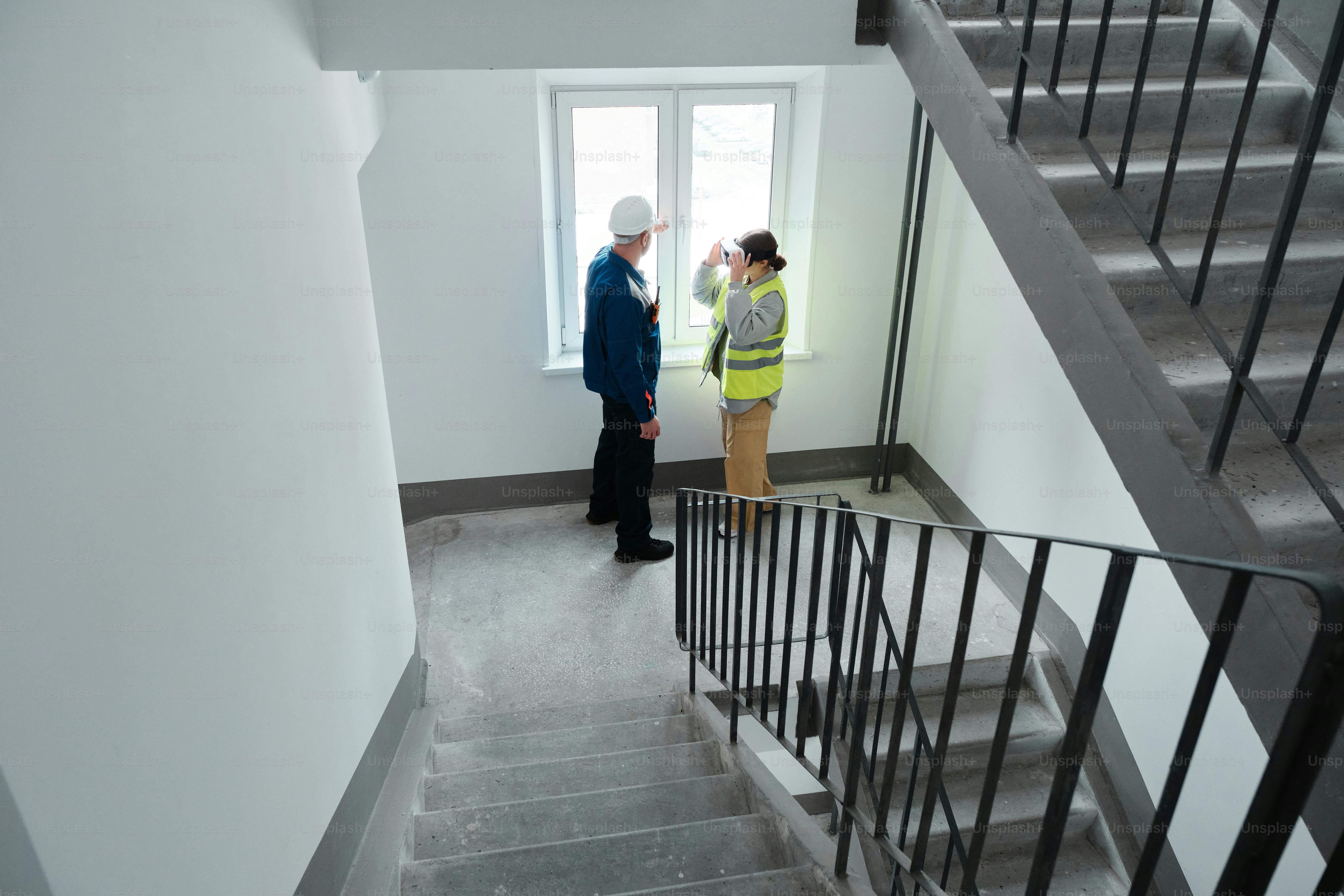 A couple of people that are standing in a room photo – Building Image ...
