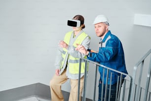 un homme portant un gilet de sécurité et une femme portant un casque virtuel